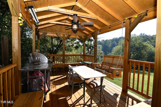 wooden deck with ceiling fan and a yard