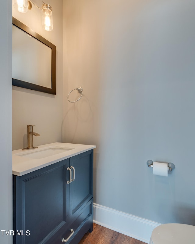 bathroom featuring hardwood / wood-style floors, vanity, and toilet