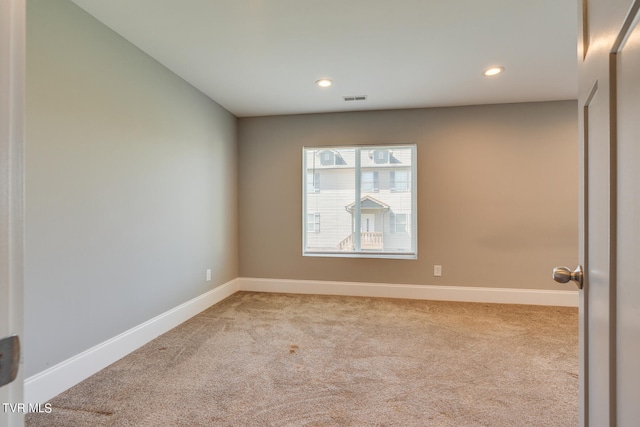 unfurnished room featuring light carpet