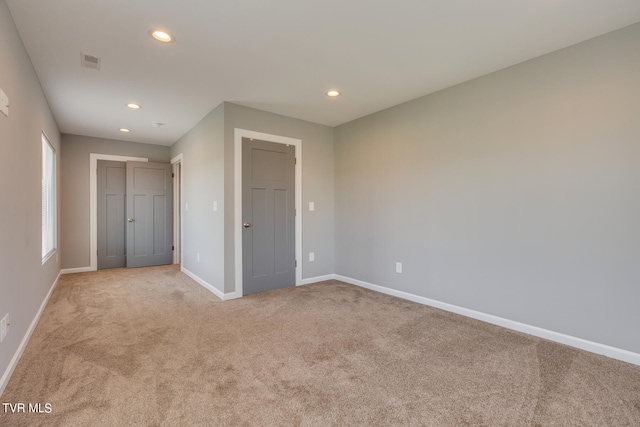 unfurnished bedroom with light colored carpet