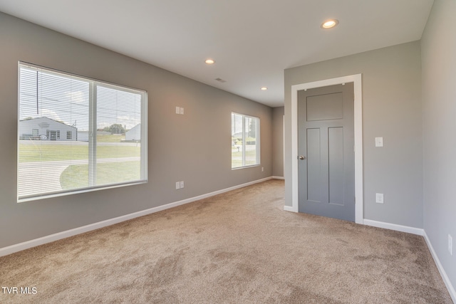 spare room featuring light colored carpet