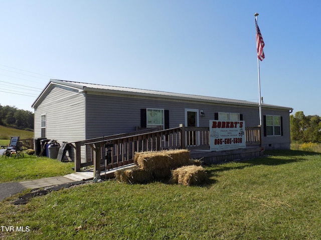 view of front facade with a wooden deck and a front yard