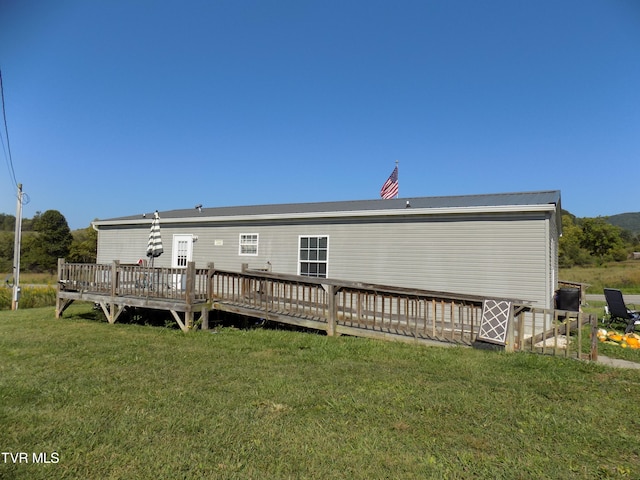 back of property featuring a deck and a yard