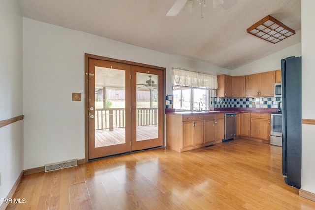 kitchen featuring ceiling fan, appliances with stainless steel finishes, light hardwood / wood-style floors, and a healthy amount of sunlight