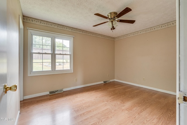 spare room with ceiling fan, a textured ceiling, and light wood-type flooring