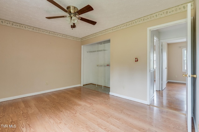 unfurnished bedroom featuring ceiling fan, a textured ceiling, a closet, and light hardwood / wood-style floors