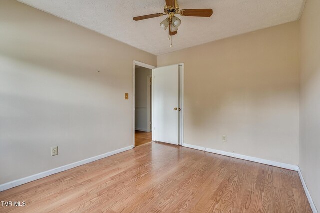 empty room with a textured ceiling, light hardwood / wood-style floors, and ceiling fan