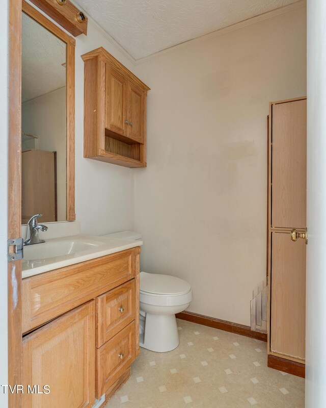 bathroom featuring a textured ceiling, vanity, toilet, and radiator heating unit