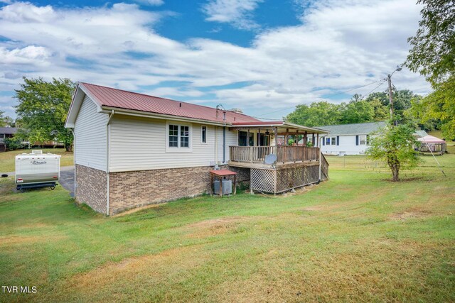 back of house with a deck and a yard