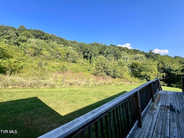 wooden terrace featuring a lawn