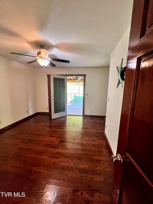 spare room featuring french doors, dark hardwood / wood-style floors, and ceiling fan