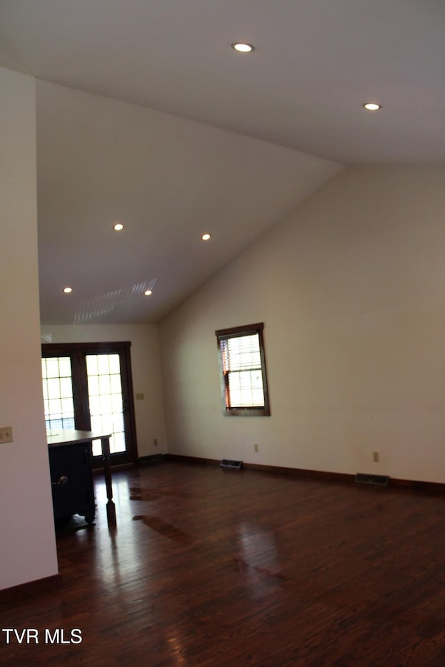 empty room with french doors, dark hardwood / wood-style flooring, a healthy amount of sunlight, and vaulted ceiling