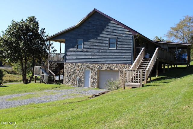 view of property exterior with a garage, a yard, and a deck