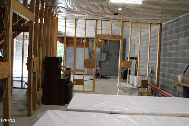 bedroom featuring electric panel and concrete flooring