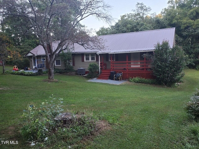 back of house featuring a yard and central air condition unit