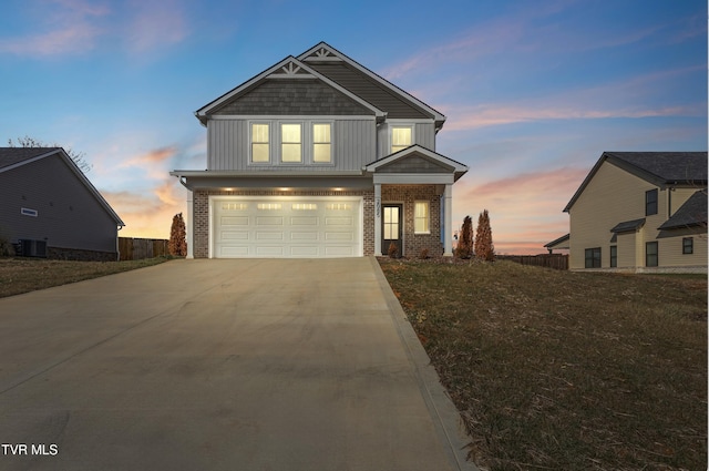 craftsman house with central AC unit, a garage, and a yard