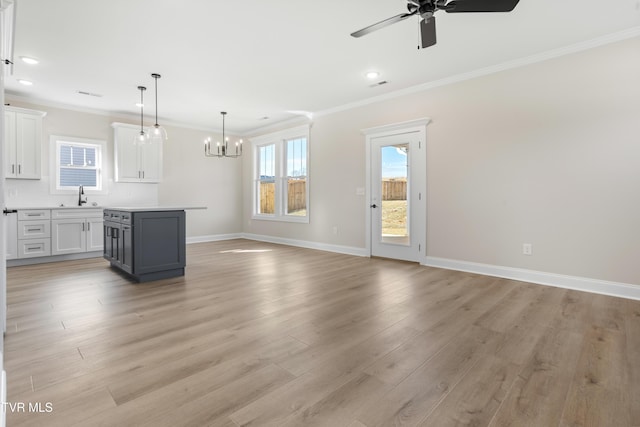 unfurnished living room with ornamental molding, sink, and light hardwood / wood-style floors