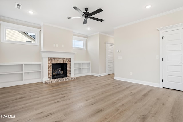 unfurnished living room with ornamental molding, a healthy amount of sunlight, a fireplace, and light wood-type flooring