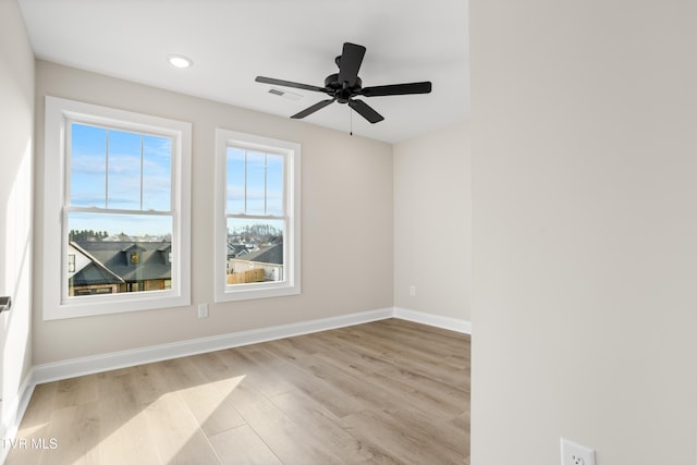 empty room with ceiling fan and light hardwood / wood-style flooring