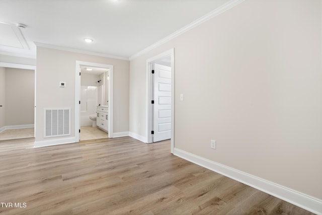 empty room featuring ornamental molding and light wood-type flooring