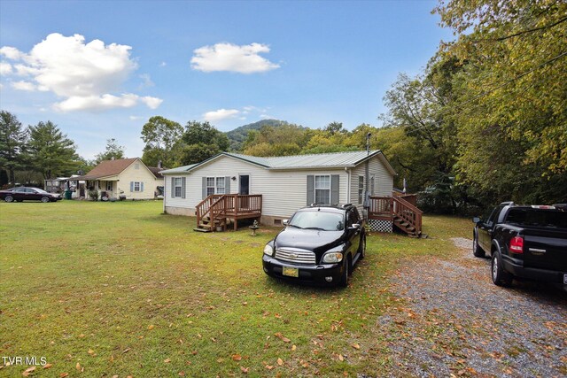 manufactured / mobile home with a deck and a front lawn