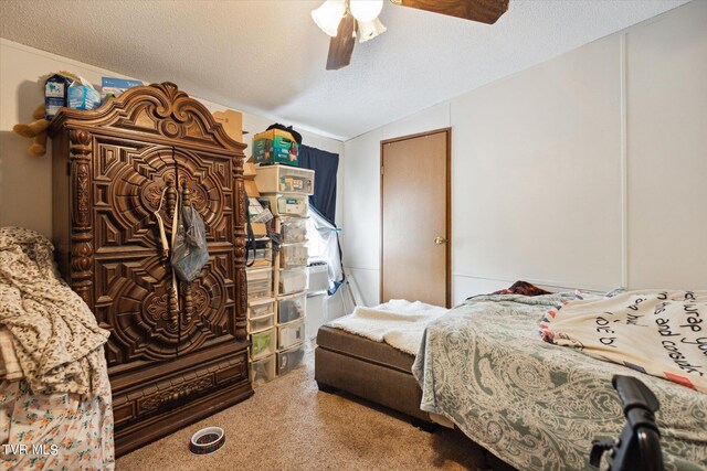 bedroom with a textured ceiling, carpet, lofted ceiling, and ceiling fan