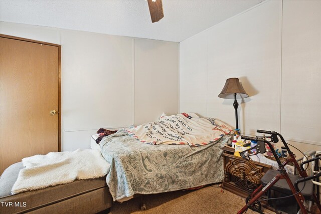 bedroom featuring carpet floors, a textured ceiling, and ceiling fan