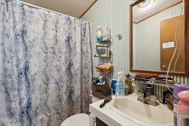 bathroom with vanity, ornamental molding, a textured ceiling, a shower with curtain, and toilet