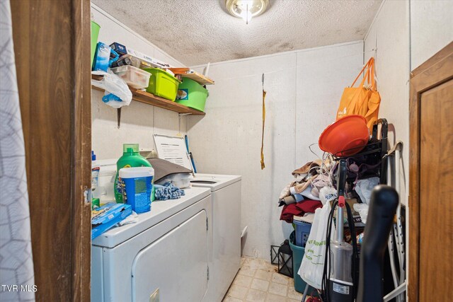 laundry area with a textured ceiling and washer and clothes dryer