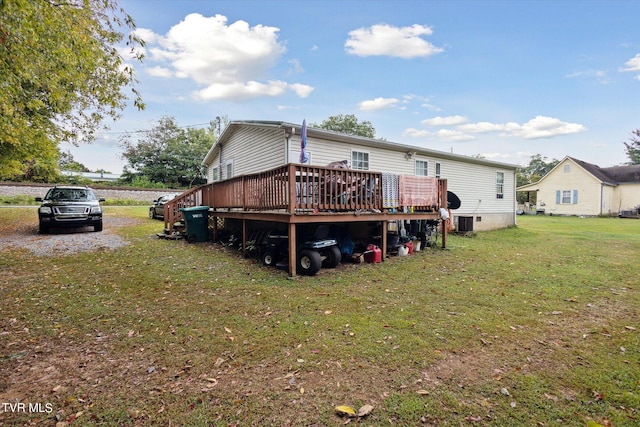 back of house featuring a lawn, central AC, and a wooden deck