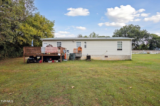 rear view of property featuring a wooden deck, a yard, and central AC