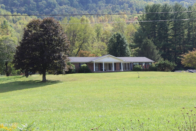 ranch-style house with a porch and a front lawn