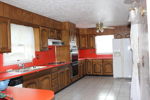 kitchen featuring sink, exhaust hood, appliances with stainless steel finishes, light tile patterned floors, and ceiling fan