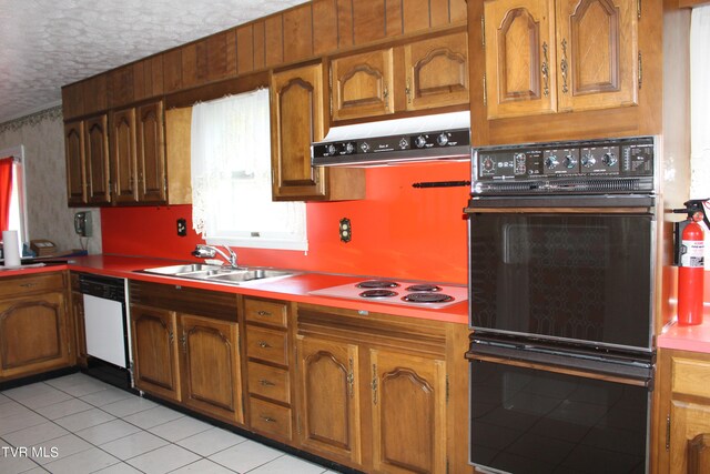 kitchen with light tile patterned floors, a textured ceiling, sink, and white appliances