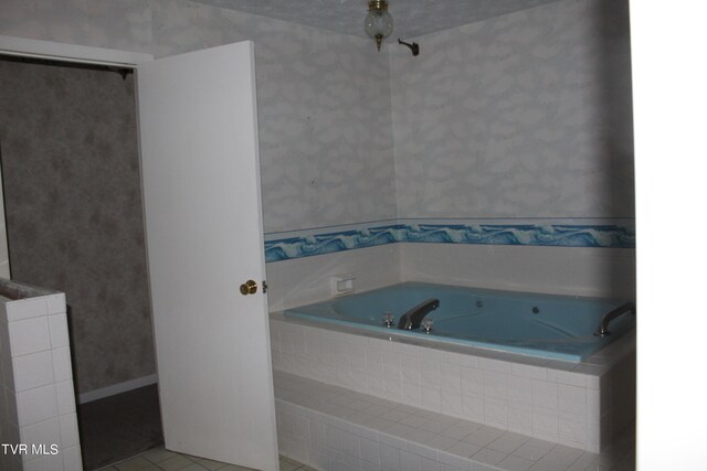 bathroom with tiled bath and tile patterned floors