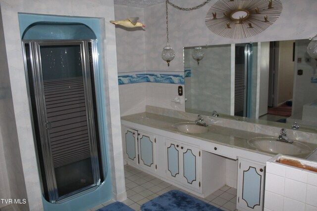 bathroom featuring tile patterned flooring, a shower with door, and vanity