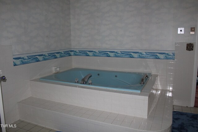 bathroom with tile patterned flooring and tiled bath