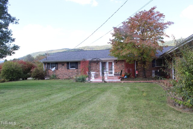 ranch-style home with a front yard and a patio