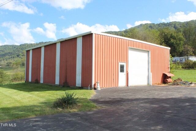 view of outdoor structure with a yard and a garage