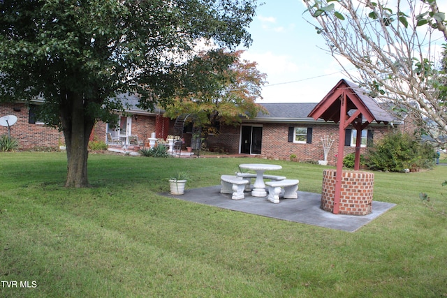 back of house with a yard and a patio