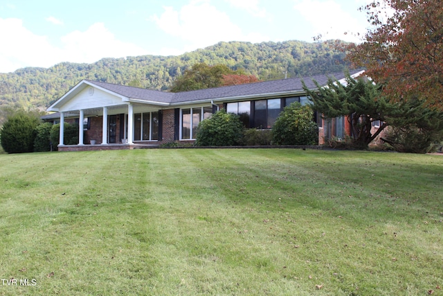 ranch-style home featuring a mountain view and a front lawn