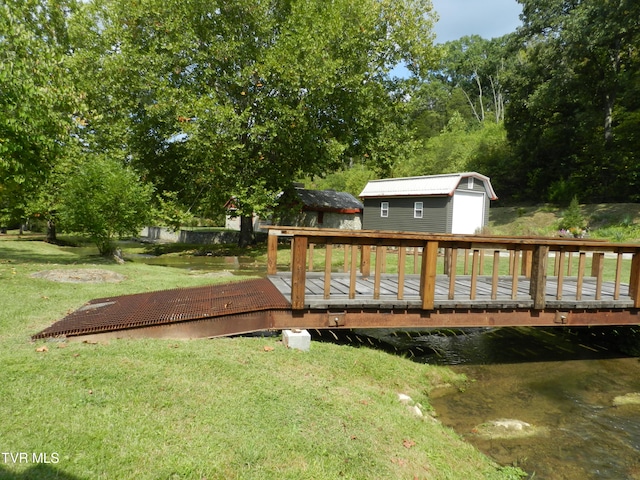 exterior space with a water view, a yard, and a storage unit