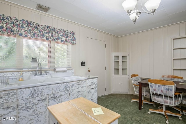 kitchen with dark carpet, sink, and a chandelier