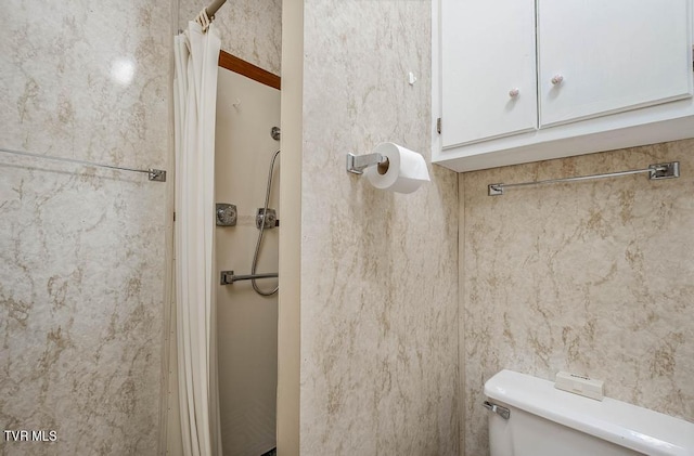 bathroom with toilet and a shower with shower curtain