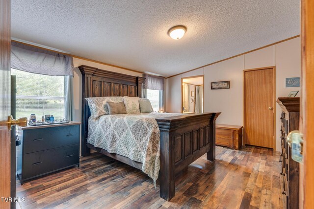 bedroom with a textured ceiling, dark hardwood / wood-style floors, and crown molding