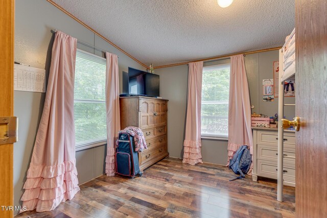 interior space with a textured ceiling, crown molding, dark hardwood / wood-style floors, and plenty of natural light