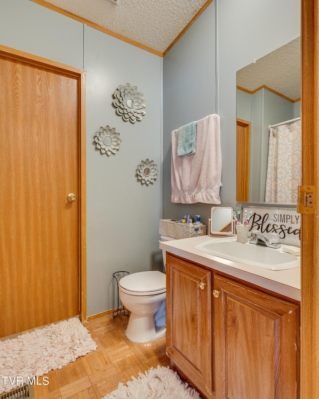 bathroom featuring vanity, ornamental molding, a textured ceiling, and toilet