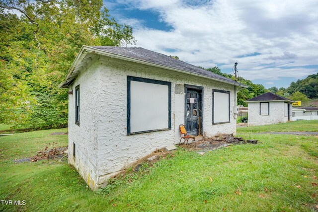 view of front of home with a front yard and an outdoor structure