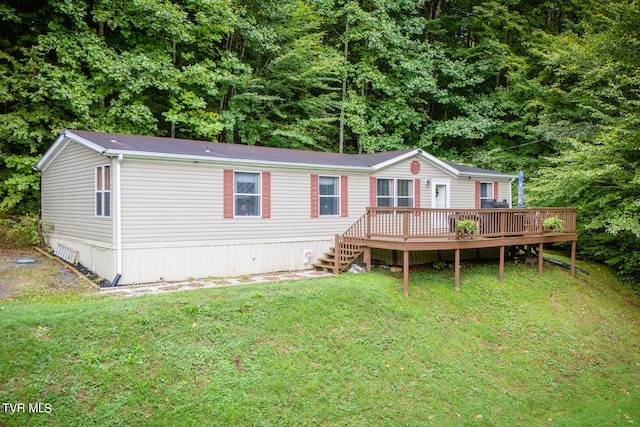 rear view of property with a deck and a yard