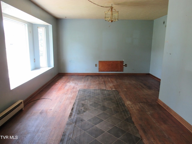 unfurnished room with an inviting chandelier, baseboard heating, dark hardwood / wood-style floors, and a textured ceiling